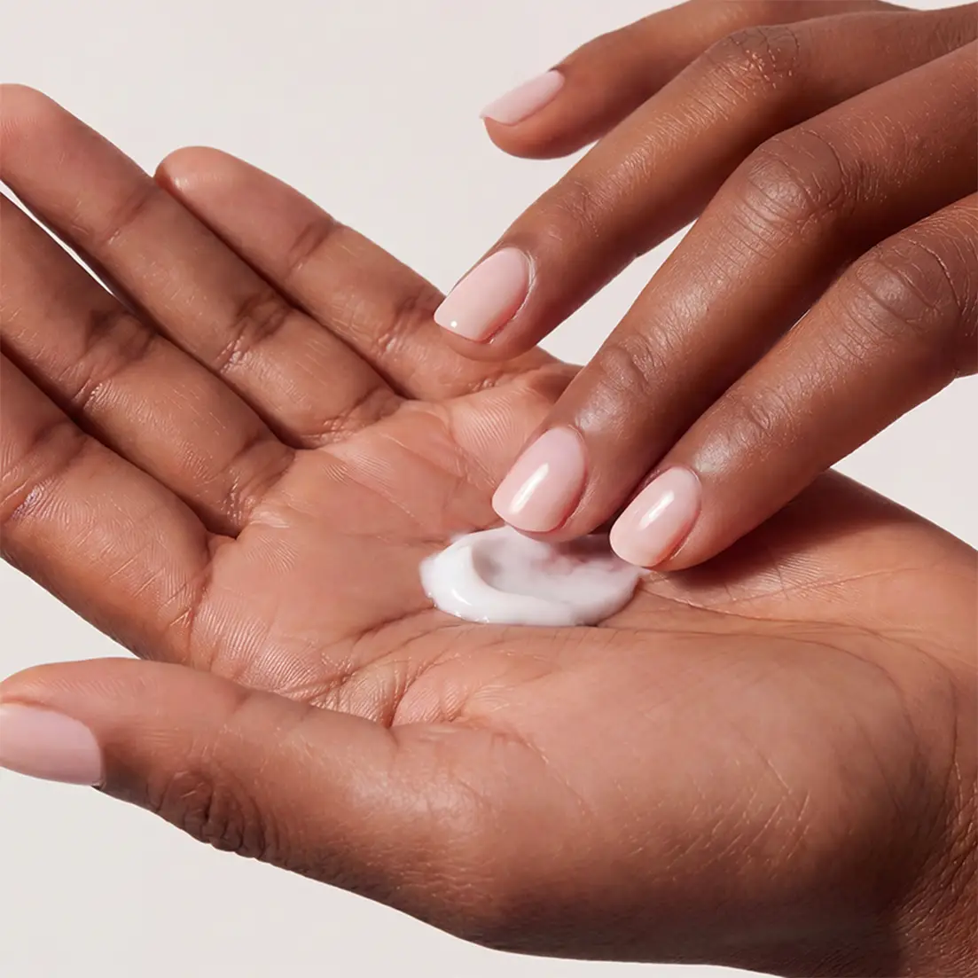 Closeup of hands applying hand cream